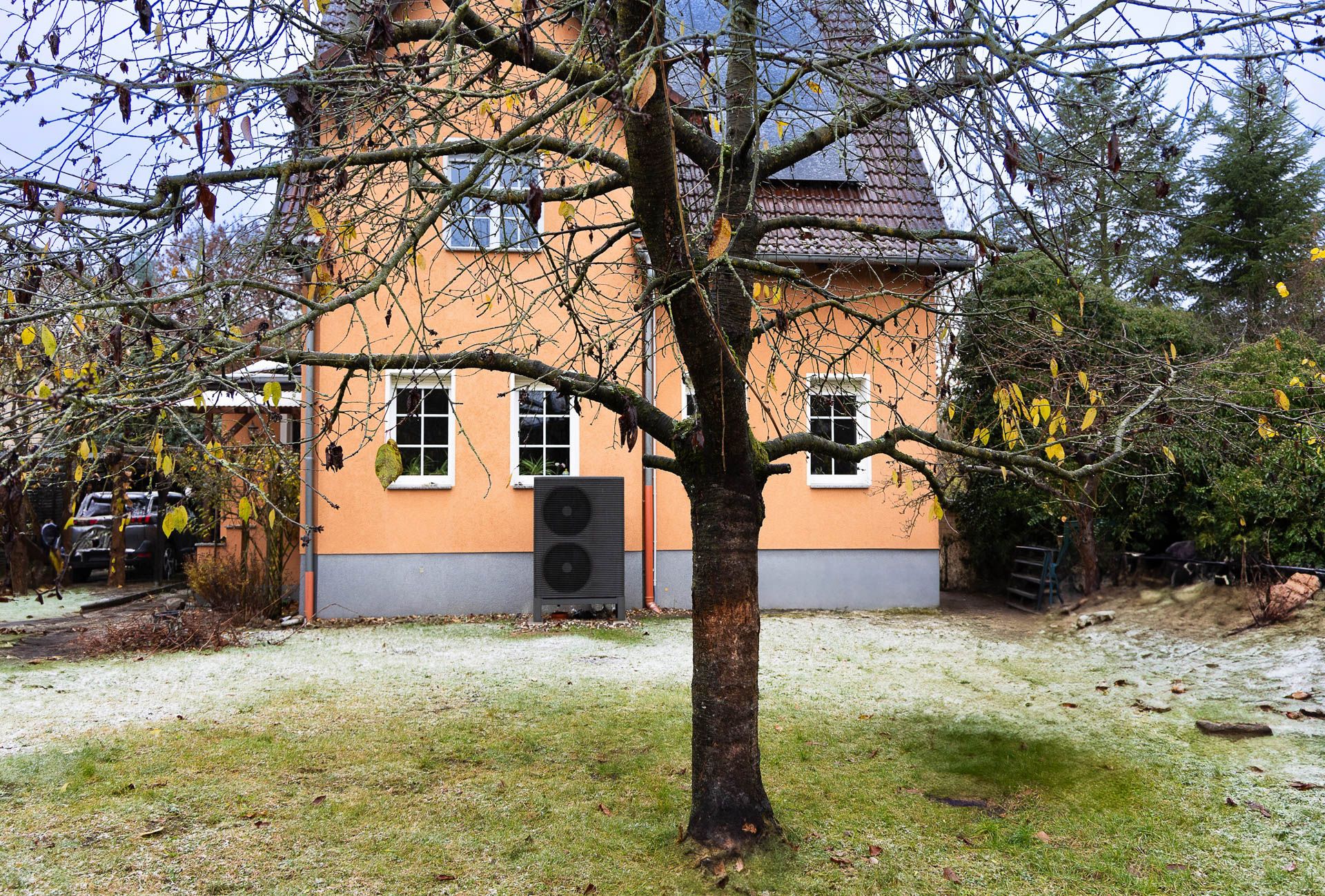 Altbau aus dem Jahr 1918 mit einer Wärmepumpe an der Hauswand