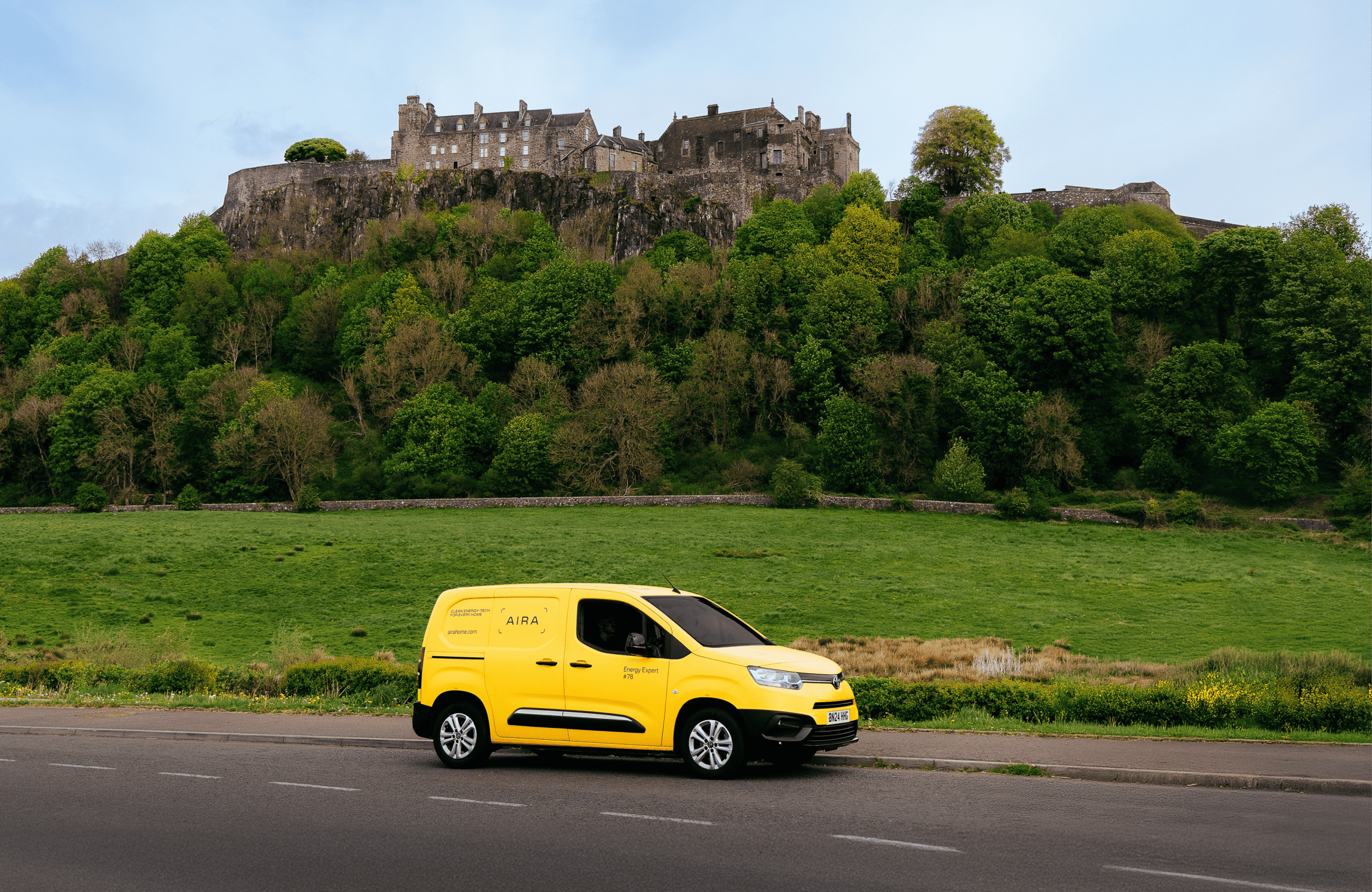 Aira Van driving through Scotland with a caslte in the background