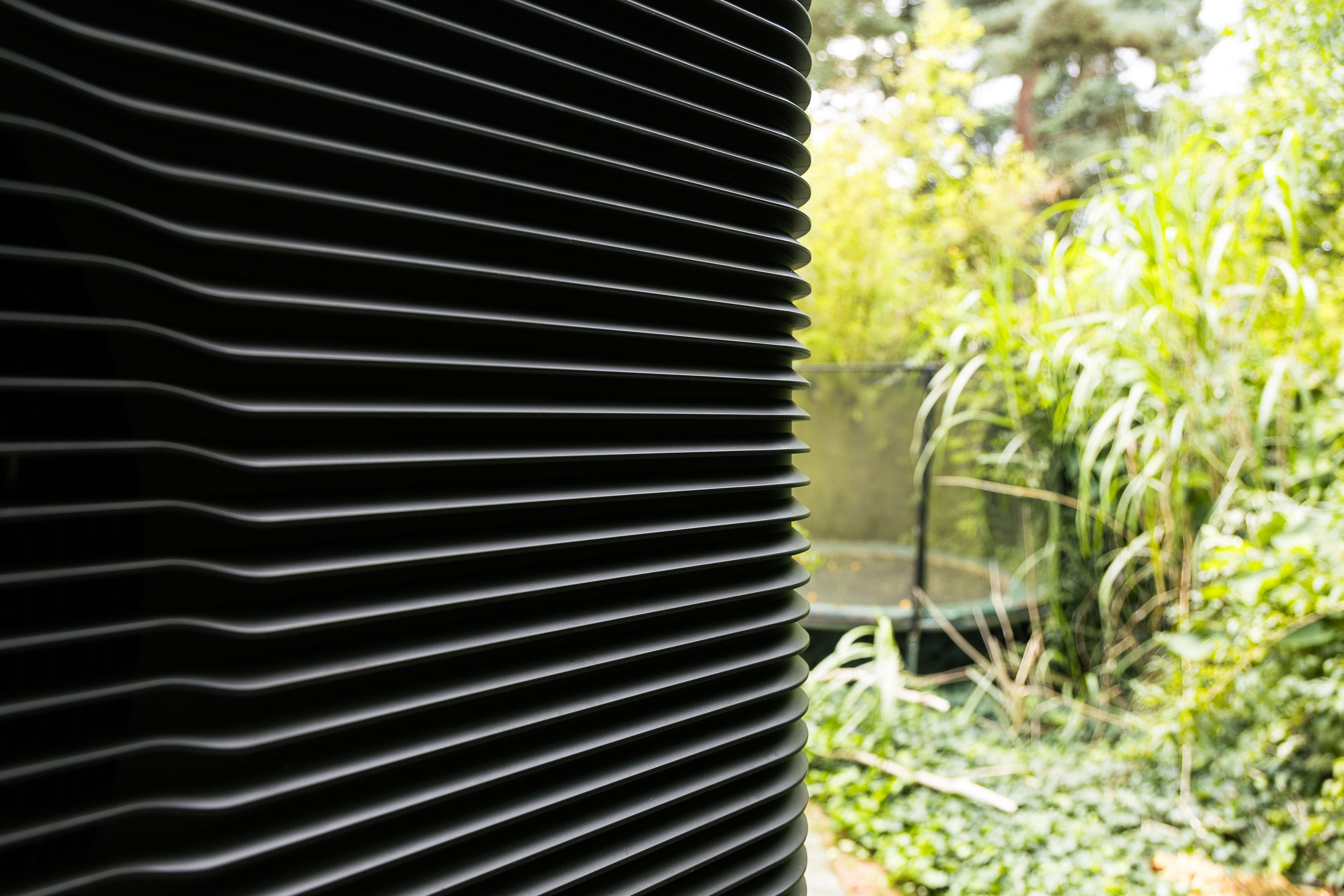 Abgeschnittene Frontansicht einer Wärmepumpe im Garten
