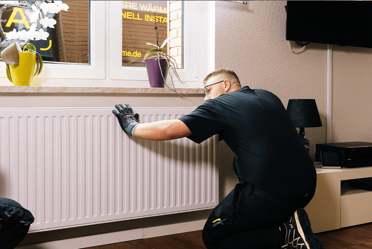Ein Installateur installiert einen Heizkörper im Haus