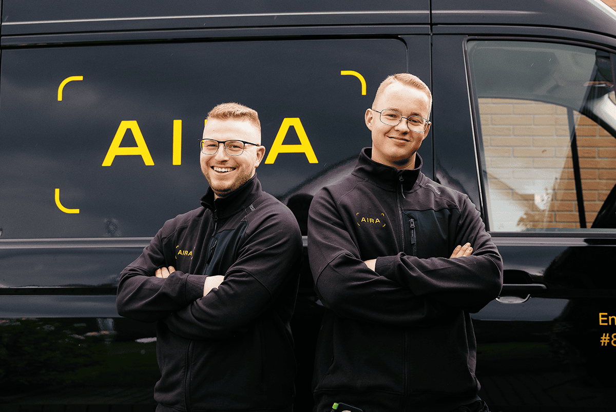 Zwei Installateure von Aira stehen vor einem Aira-Auto